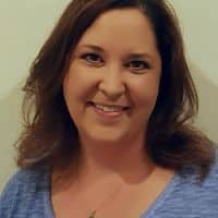 Smiling woman with brown hair wearing a blue shirt. Professional window cleaning services in Gilbert, AZ.